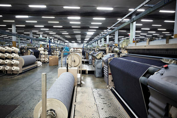 Weaving fabric on air jet looms in big textile weaving unit.