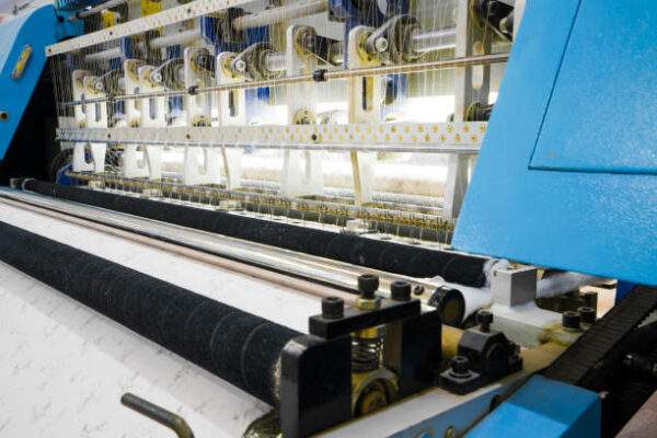 weaving loom at a textile factory, closeup. industrial fabric production line