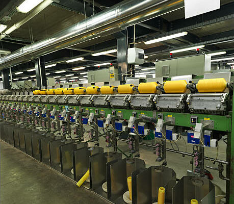 "detail of an indoor industrial production line, in a thread factory"