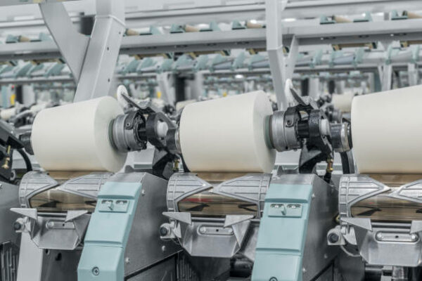 Machinery and equipment in the workshop for the production of thread, close-up. interior of industrial textile factory