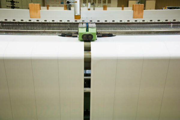 Industrial fabric production line. Weaving looms at a textile factory